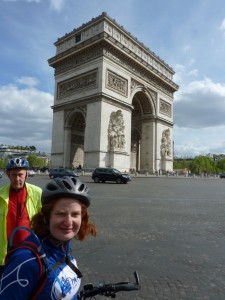 Lucy at the Arc de Triomphe with a fellow cyclist in the background